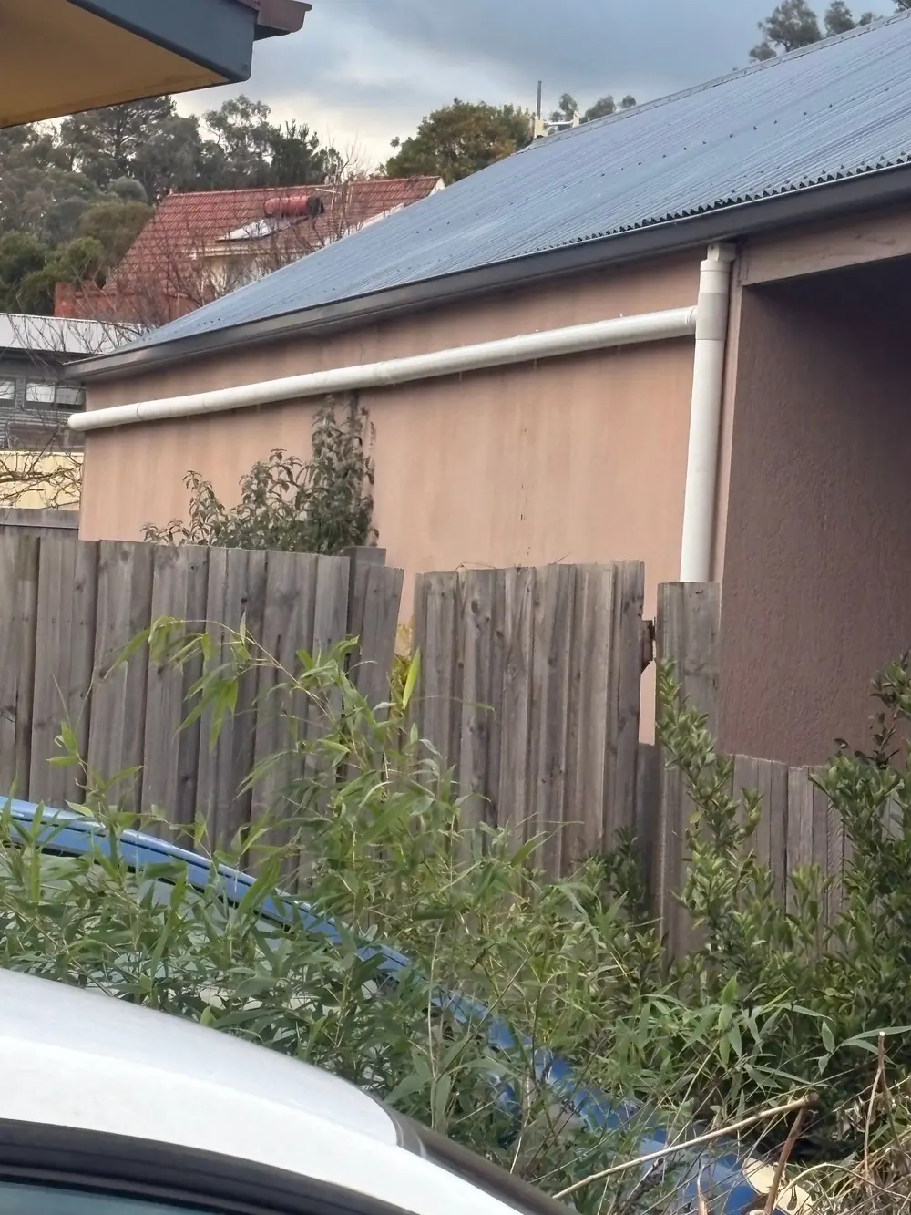 External downpipe installation along a residential wall