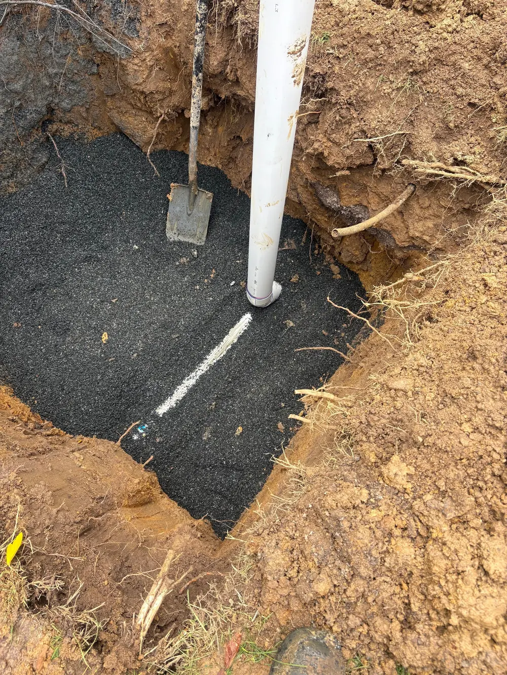 Drainage pipework exposed in an excavated trench